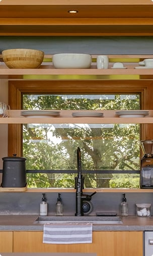 wooden kitchen counters that features a sink and storage for cutlery.